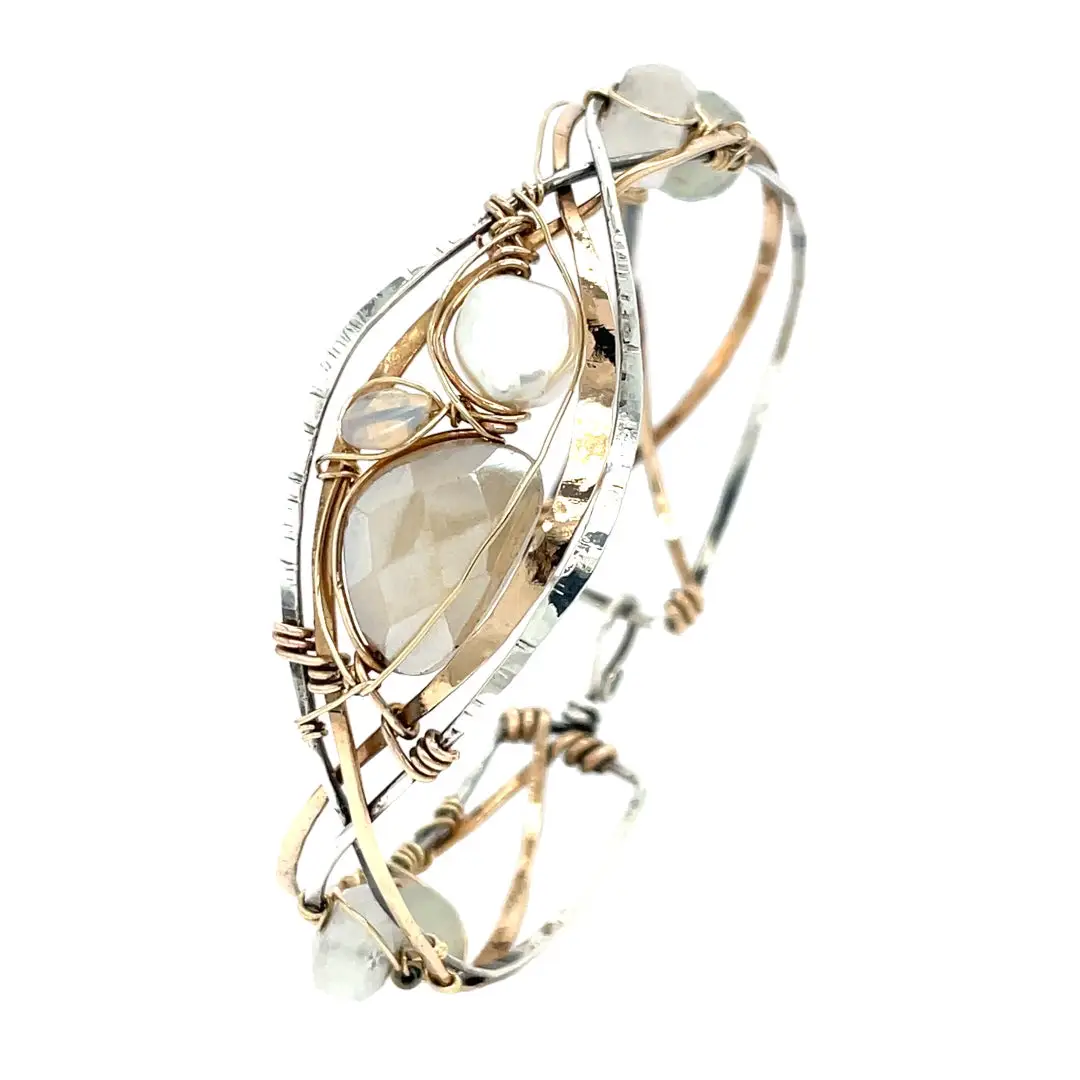 Sterling, darkened sterling, and bronze hammered waves form a cuff bracelet accented with moonstone, opal, fresh water pearl, and prehnite gemstones on gold filled wire