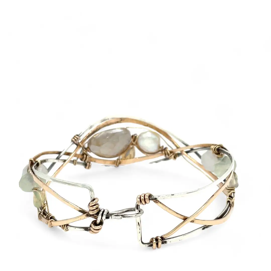 Sterling, darkened sterling, and bronze hammered waves form a cuff bracelet accented with moonstone, opal, fresh water pearl, and prehnite gemstones on gold filled wire