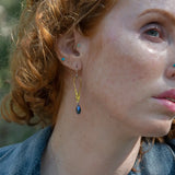 Stamped brass upside down teardrop earrings with blue crystal drop hanging from the bottom