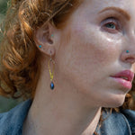 Stamped brass upside down teardrop earrings with blue crystal drop hanging from the bottom