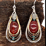 Sterling silver handmade drop earrings with carnelian, pyrite, blue fresh water pearl, red cubic zirconia, and green amethyst carved hand within layers of gold filled and brass wires