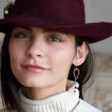 A pair of cascade style garnet earrings with faceted sphere gemstones, handmade brass hoops, and suspending oxidized sterling silver chains with a deep red freshwater pearl.