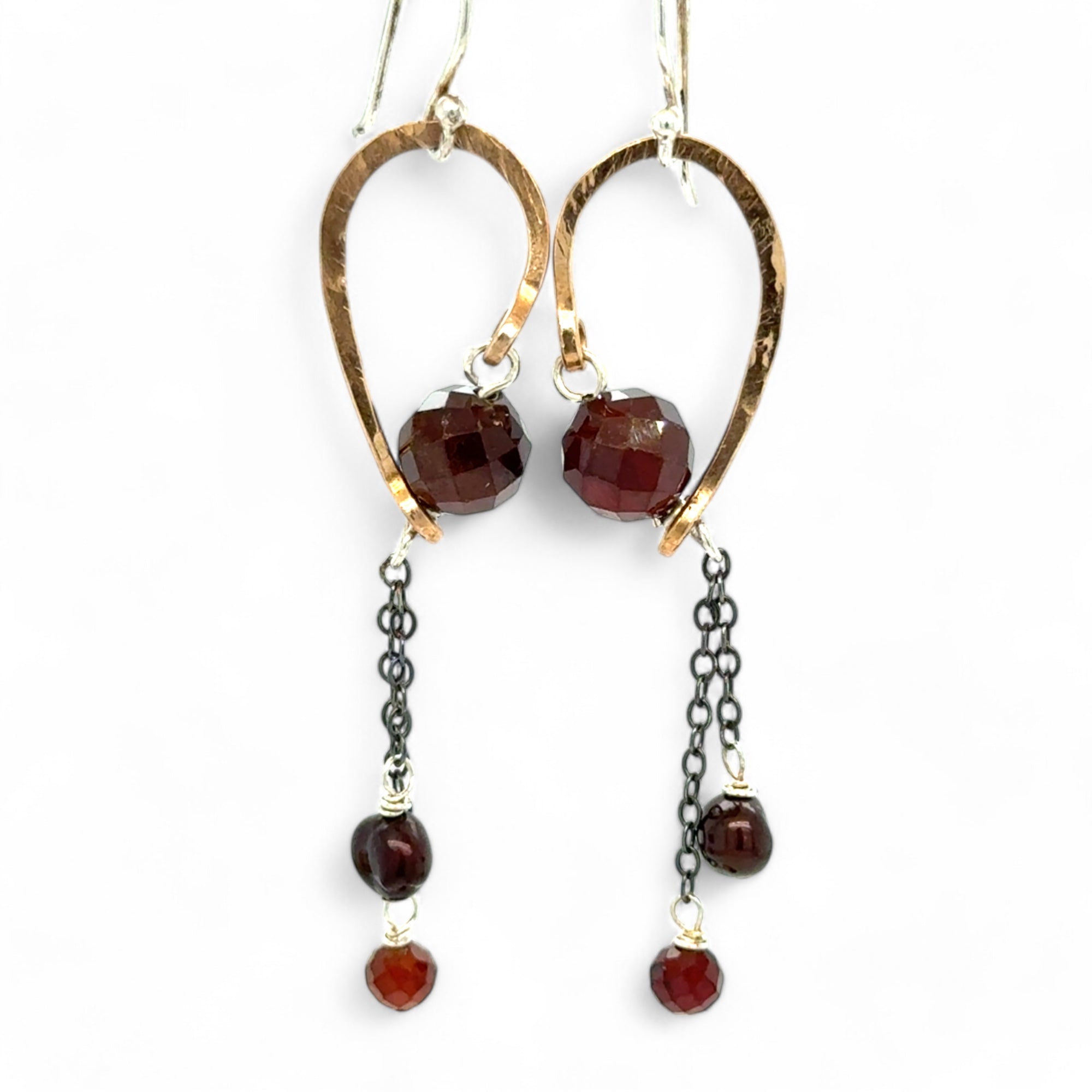 A pair of cascade style garnet earrings with faceted sphere gemstones, handmade brass hoops, and suspending oxidized sterling silver chains with a deep red freshwater pearl.