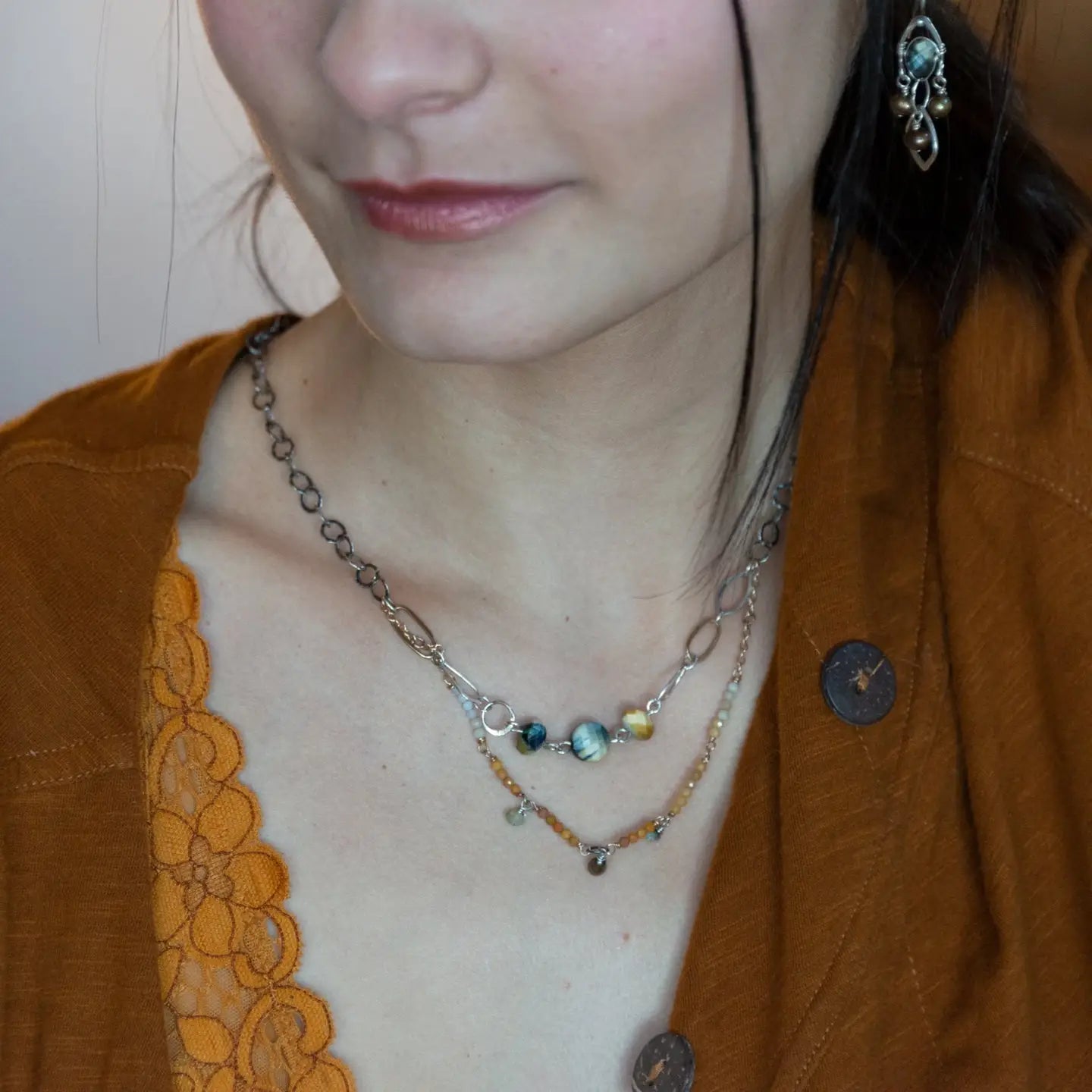 A double strand necklace with one strand featuring hammered brass and sterling silver handmade links and cat's eye faceted gemstones, and the other strand with faceted ombre mookaite and tiny pearl accents.