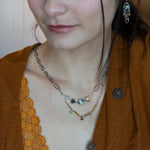 A double strand necklace with one strand featuring hammered brass and sterling silver handmade links and cat's eye faceted gemstones, and the other strand with faceted ombre mookaite and tiny pearl accents.