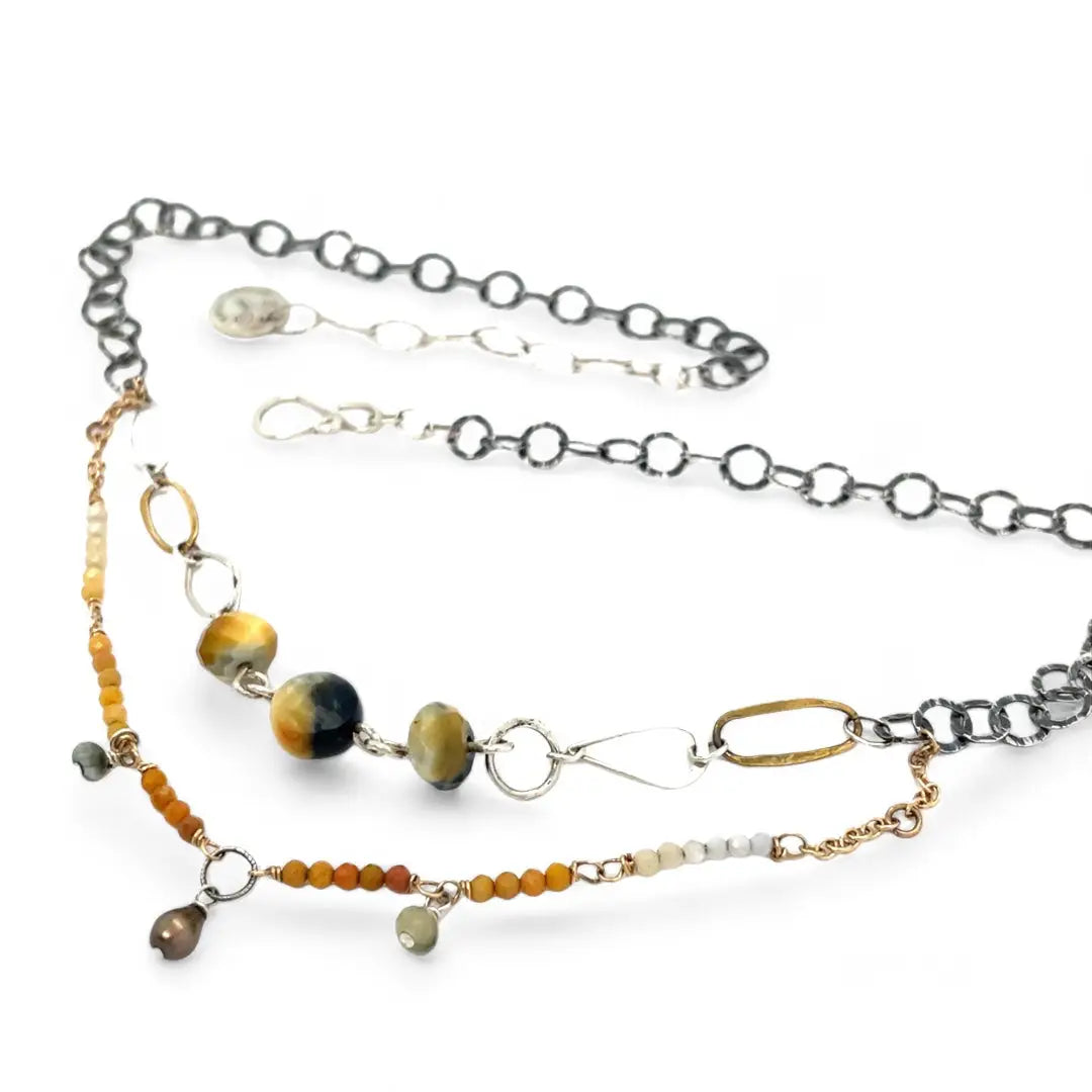 A double strand necklace with one strand featuring hammered brass and sterling silver handmade links and cat's eye faceted gemstones, and the other strand with faceted ombre mookaite and tiny pearl accents.