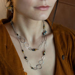 handmade hammered marquise links mixed with cat's eye gemstones, sparkly sterling silver links, and sterling silver chain form a long necklace