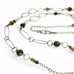 handmade hammered marquise links mixed with cat's eye gemstones, sparkly sterling silver links, and sterling silver chain form a long necklace