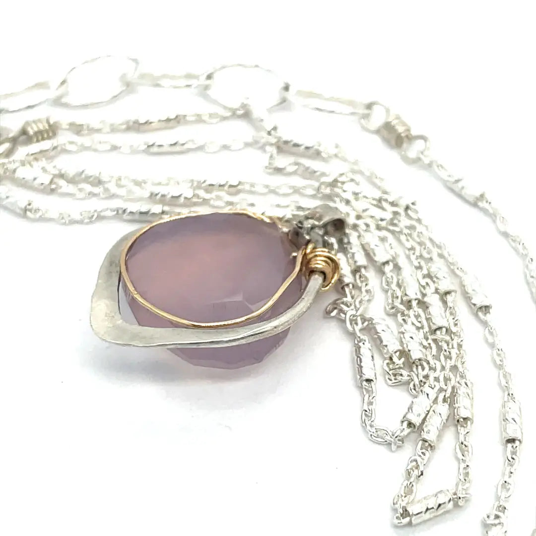 A sterling silver mini necklace with a teardrop-shaped pink chalcedony and sterling silver pendant on a sparkling sterling silver dash chain