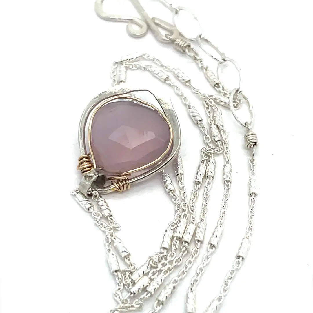 A sterling silver mini necklace with a teardrop-shaped pink chalcedony and sterling silver pendant on a sparkling sterling silver dash chain