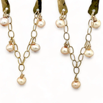 Shiny brass arch earrings with gold-filled chain cascading with champagne colored fresh water pearls.