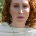 Shiny brass arch earrings with gold-filled chain cascading with champagne colored fresh water pearls.