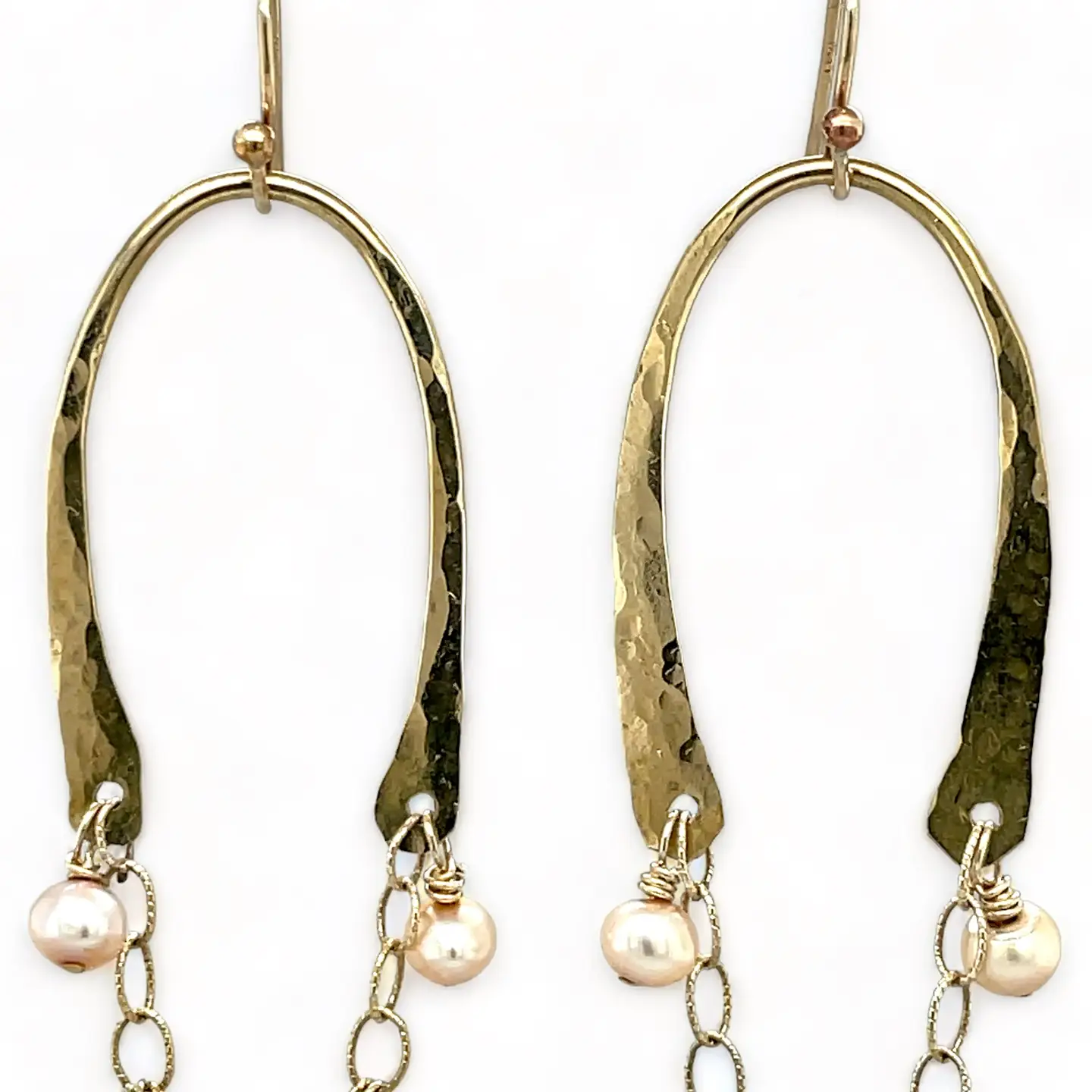 Shiny brass arch earrings with gold-filled chain cascading with champagne colored fresh water pearls.