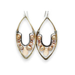 Pink and champagne colored fresh water pearls combined with a peach opalescent faceted drop gemstone sit inside a brass stamped marquise earring with sterling silver accent
