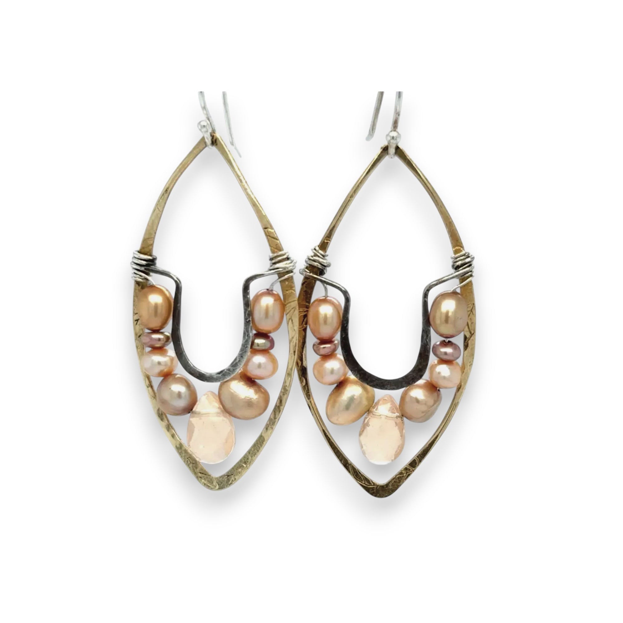 Pink and champagne colored fresh water pearls combined with a peach opalescent faceted drop gemstone sit inside a brass stamped marquise earring with sterling silver accent