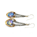 Handmade leaf stamped brass chariots hanging from double up oxidized sterling silver dainty chain, holding a blue faceted hexagonal crystal earring