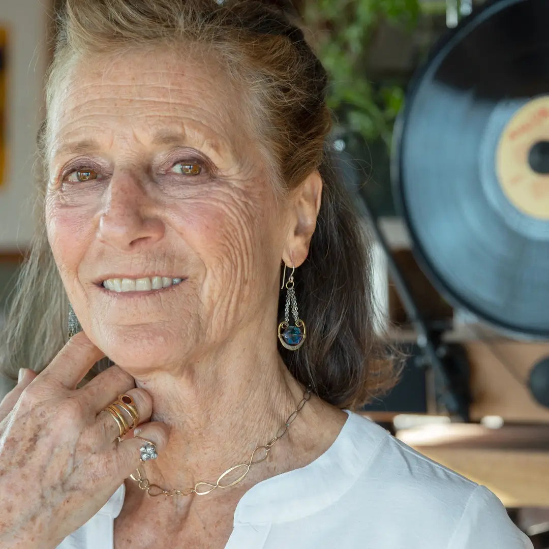 Handmade leaf stamped brass chariots hanging from double up oxidized sterling silver dainty chain, holding a blue faceted hexagonal crystal earring