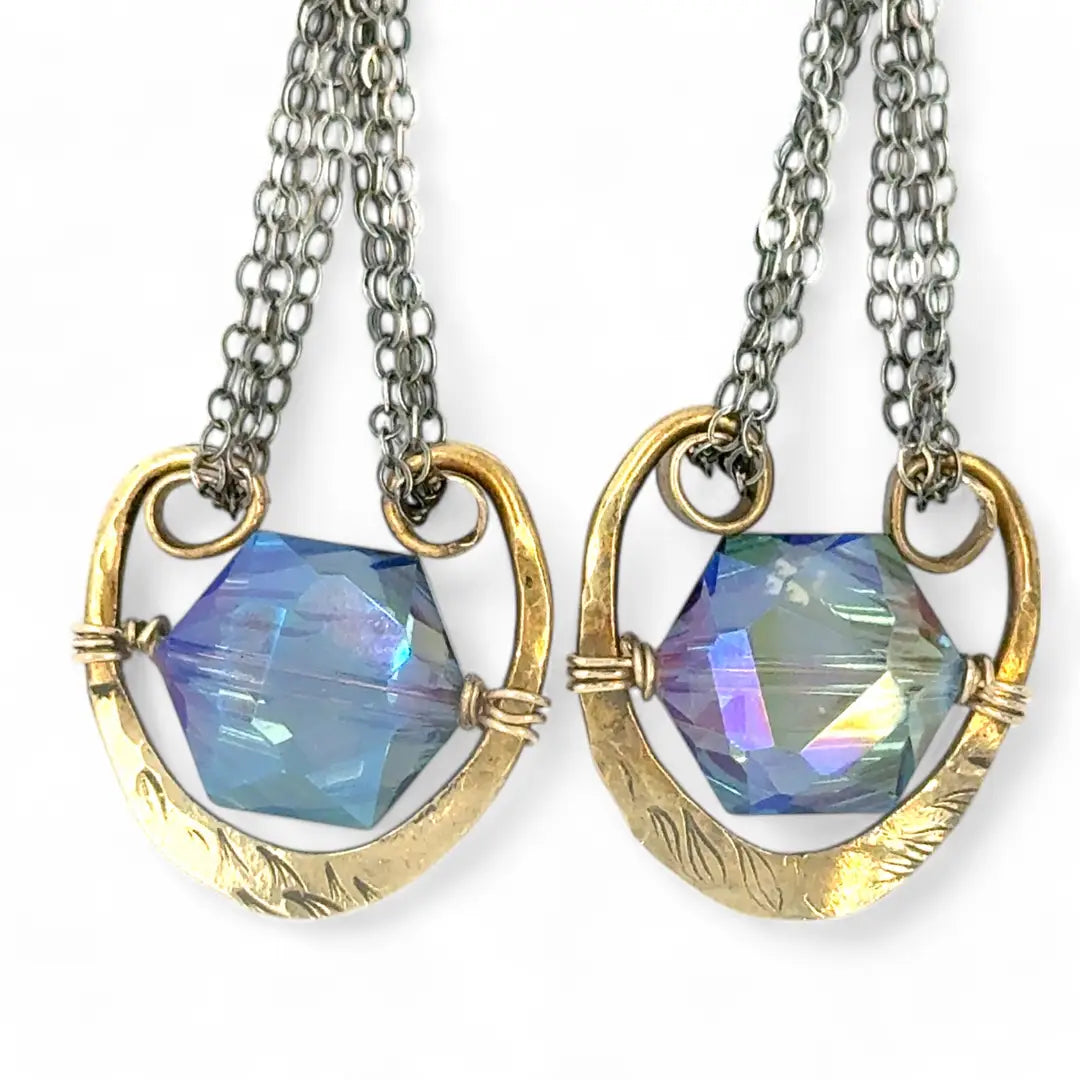 Handmade leaf stamped brass chariots hanging from double up oxidized sterling silver dainty chain, holding a blue faceted hexagonal crystal earring