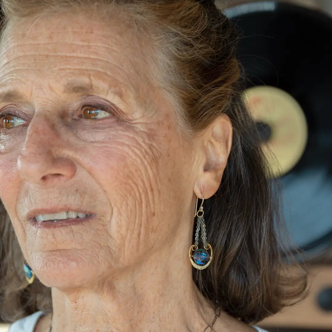 Handmade leaf stamped brass chariots hanging from double up oxidized sterling silver dainty chain, holding a blue faceted hexagonal crystal earring