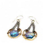 Handmade leaf stamped brass chariots hanging from double up oxidized sterling silver dainty chain, holding a blue faceted hexagonal crystal earring