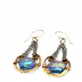 Handmade leaf stamped brass chariots hanging from double up oxidized sterling silver dainty chain, holding a blue faceted hexagonal crystal earring