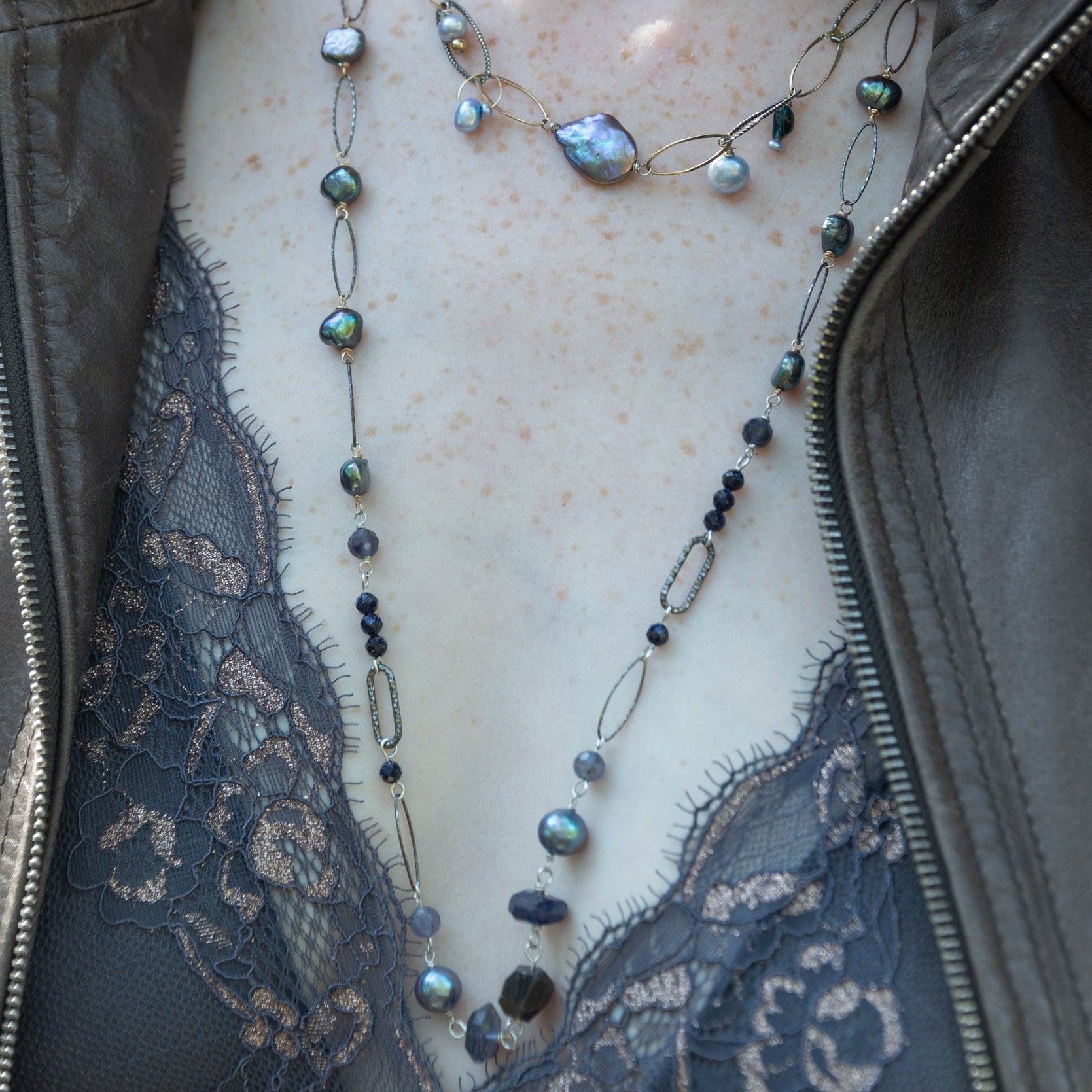 Iolite nugget gemstones, blue/purple fresh water pearls, and blue goldstone are joined together with darkened sparkly sterling silver links to create a long necklace able to layer