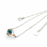 a singular faceted apatite gemstone is held in layered of hammered gold filled wire on a mini sterling silver paisley necklace