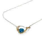 a singular faceted apatite gemstone is held in layered of hammered gold filled wire on a mini sterling silver paisley necklace