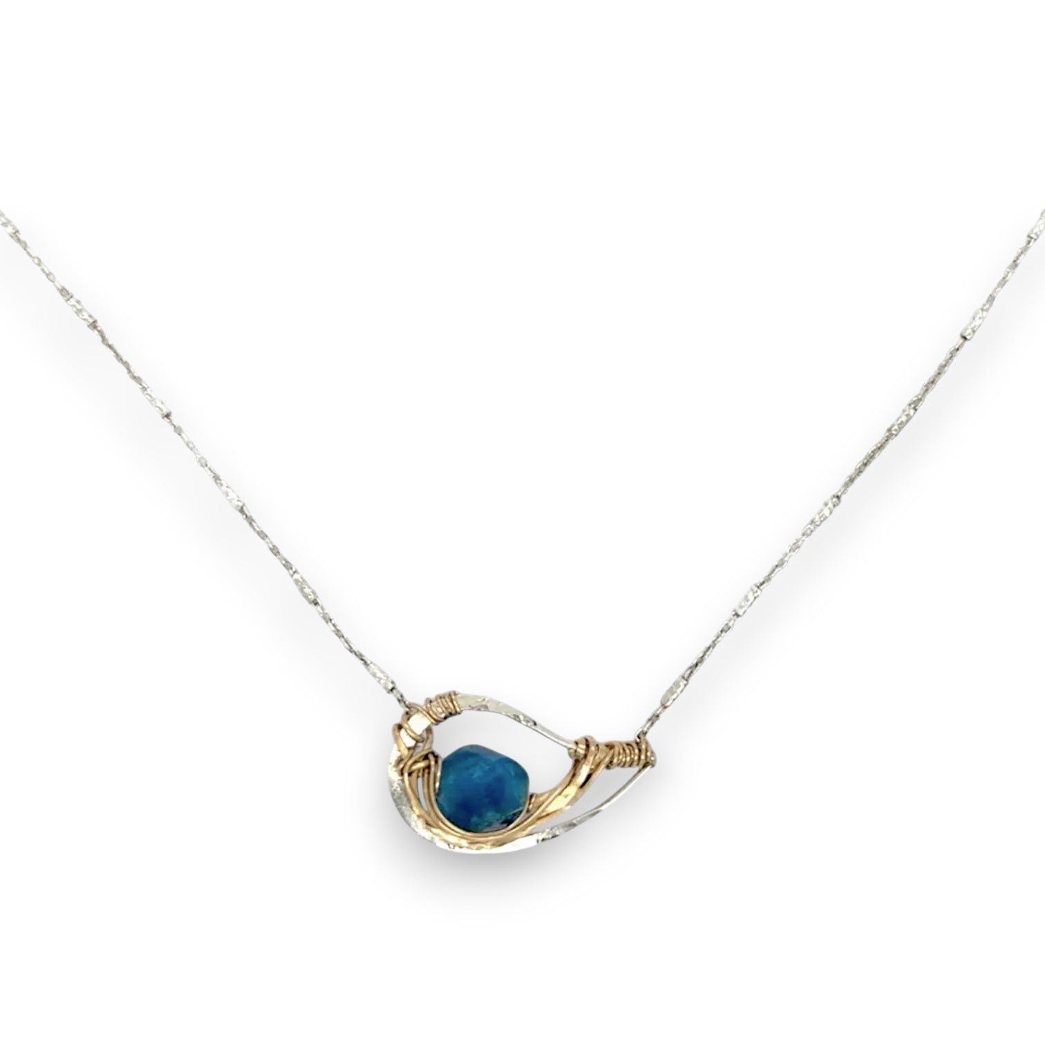 a singular faceted apatite gemstone is held in layered of hammered gold filled wire on a mini sterling silver paisley necklace