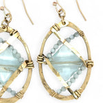 aqua quartz tiles are lined with light blue cat's eye mini gemstones and hammered brass lines in brass ovals= earrings