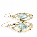 aqua quartz tiles are lined with light blue cat's eye mini gemstones and hammered brass lines in brass ovals= earrings