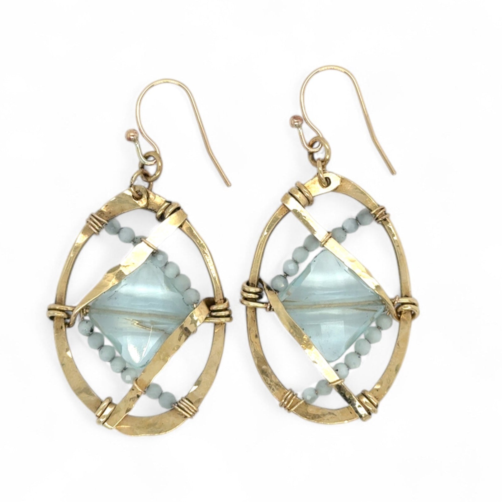 aqua quartz tiles are lined with light blue cat's eye mini gemstones and hammered brass lines in brass ovals= earrings