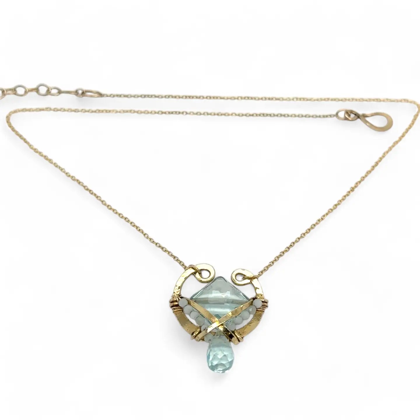 brass hammered mini pendant with aqua quartz tile lined in light blue cat's eye tiny gemstones with a faceted blue quartz drop at the bottom on gold filled chain necklace