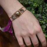 Chocolate pearl coin, striped brown agate, watermelon tourmaline, and cherry rutilated quartz gemstones held within our handmade bronze cuff on gold filled wire