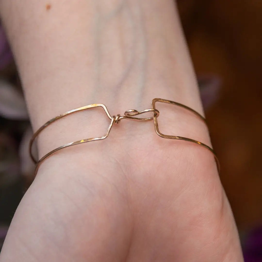 Chocolate pearl coin, striped brown agate, watermelon tourmaline, and cherry rutilated quartz gemstones held within our handmade bronze cuff on gold filled wire