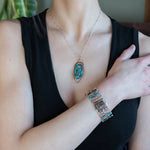 Bronze marquise pendant with a smooth chrysocolla drop nugget outlined in turquoise faceted gemstones on a sterling silver chain necklace