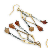 fire shaped carved hessonite garnet gemstones dangle from dark sterling silver delicate chain and brass arches and diamond earrings