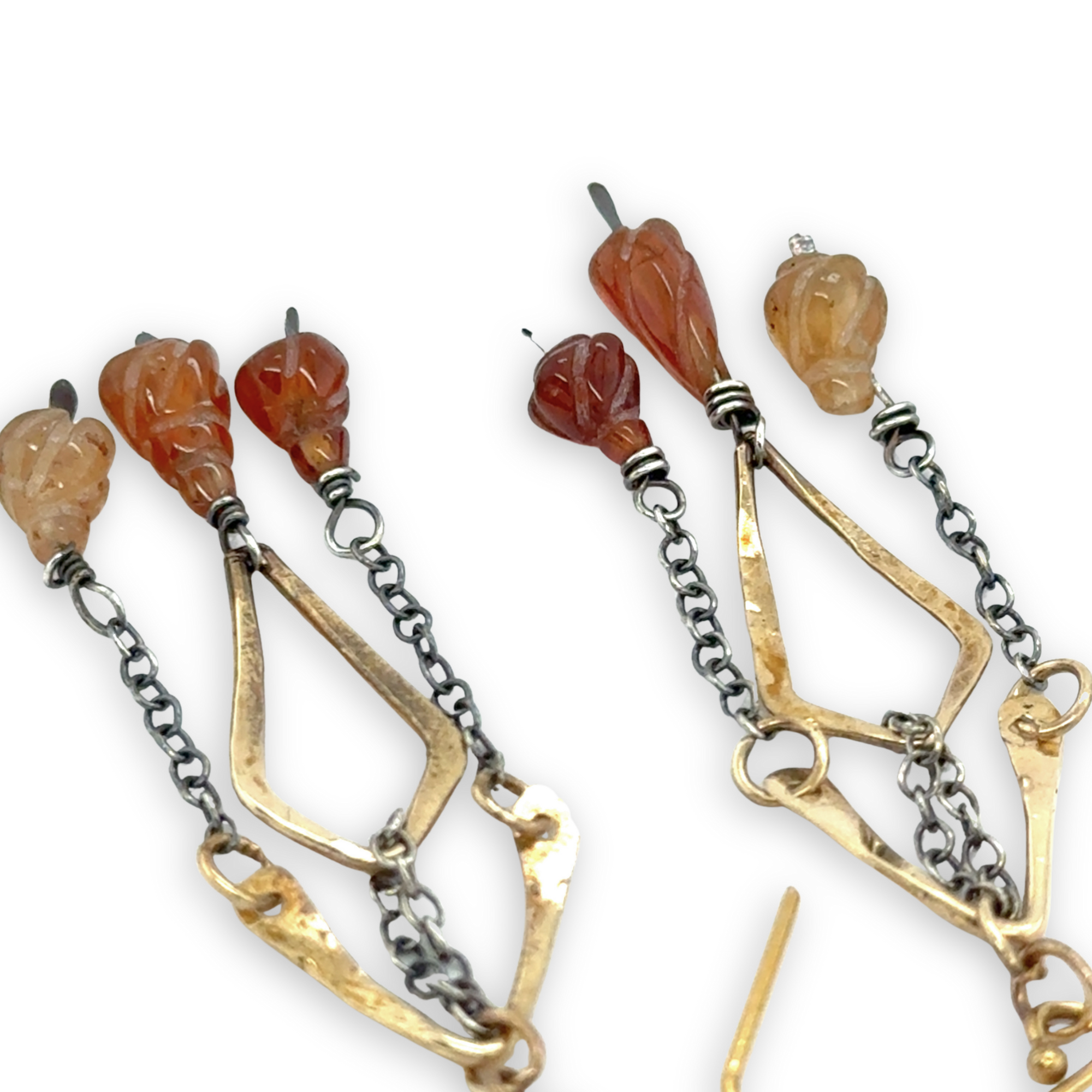 fire shaped carved hessonite garnet gemstones dangle from dark sterling silver delicate chain and brass arches and diamond earrings