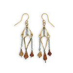 fire shaped carved hessonite garnet gemstones dangle from dark sterling silver delicate chain and brass arches and diamond earrings