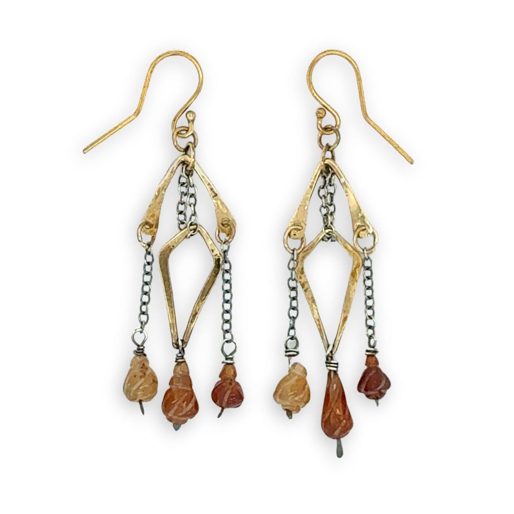fire shaped carved hessonite garnet gemstones dangle from dark sterling silver delicate chain and brass arches and diamond earrings
