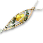 a double layered necklace, the first layer with a Bronze marquise pendant embellished with a faceted citrine coin, prehnite, and turquoise gemstones on sterling silver wire, and the second layer with delicate gemstone charms