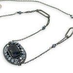 raw black tourmaline within pyrite gemstones inside a sterling silver darkened twist wire oval pendant on a darkened chain with sparkly links necklace