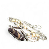 Brown oval jasper held in sterling silver is layered with fresh water pearl, gold filled chain, and pyrite gemstones to form an already layered necklace
