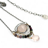 a smooth rose quartz oval is held in an oxidized sterling silver spiral pendant accompanied by tourmaline gemstones with a faceted rose quartz gemstone drop with gold filled delicate chain accent necklace