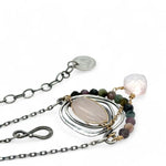 a smooth rose quartz oval is held in an oxidized sterling silver spiral pendant accompanied by tourmaline gemstones with a faceted rose quartz gemstone drop with gold filled delicate chain accent necklace