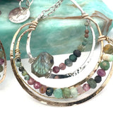 A hand formed bronze and sterling silver pendant necklace with a slide  sterling silver chain, featuring faceted natural tourmaline, green amethyst and flashy labradorite gemstones