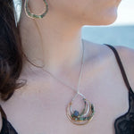 A hand formed bronze and sterling silver pendant necklace with a slide  sterling silver chain, featuring faceted natural tourmaline, green amethyst and flashy labradorite gemstones