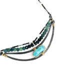A darkened sterling silver crescent necklace  featuring a bright blue druzy quartz slab and ombre blue tourmaline gemstones on gold filled wire