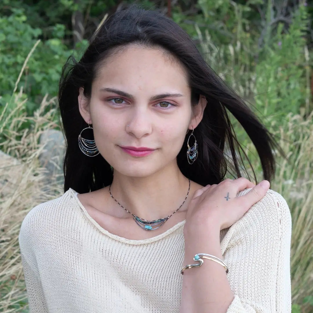 A darkened sterling silver crescent necklace  featuring a bright blue druzy quartz slab and ombre blue tourmaline gemstones on gold filled wire