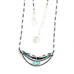 A darkened sterling silver crescent necklace  featuring a bright blue druzy quartz slab and ombre blue tourmaline gemstones on gold filled wire